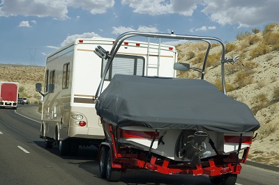 RV carrying a boat on the road